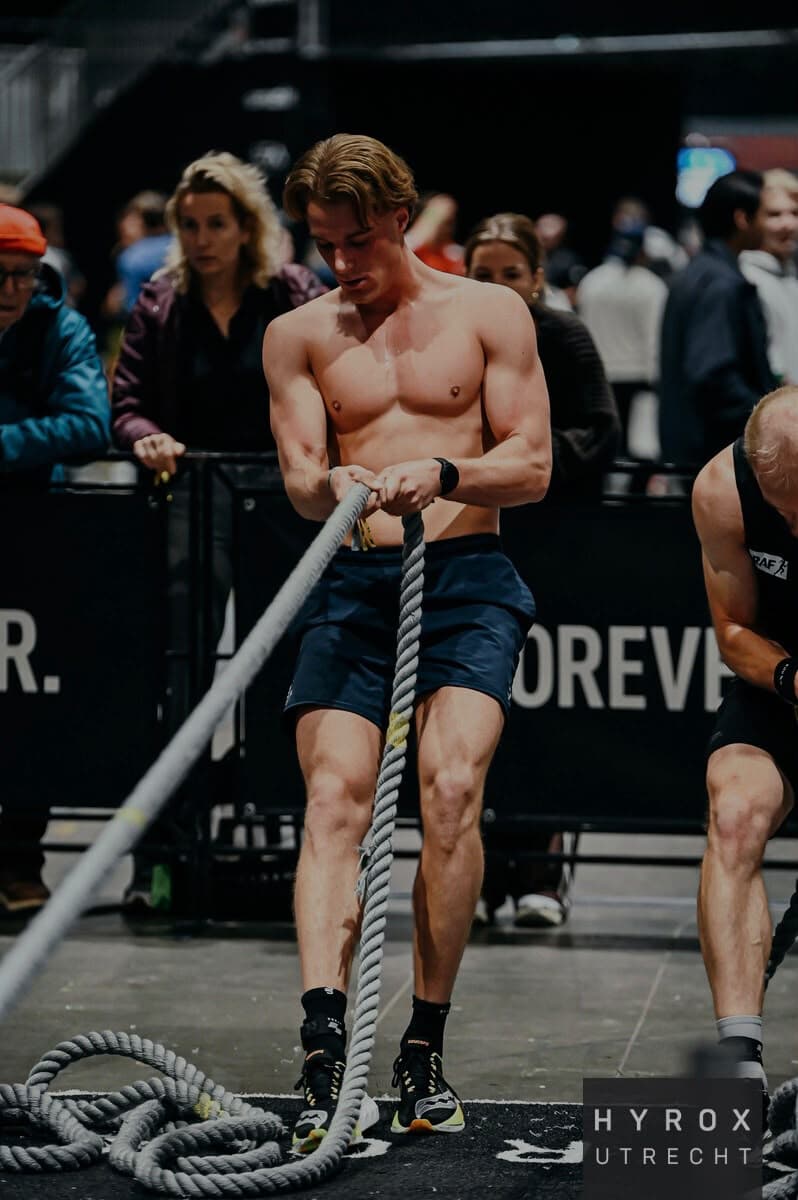 Teun trekt met een touw de sled naar zich toe tijdens HYROX Utrecht.
